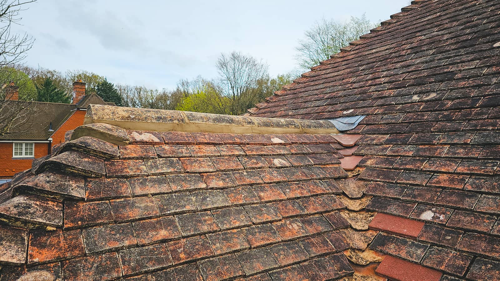 Finished lead apron and soakers at a brick chimney on a tiled roof