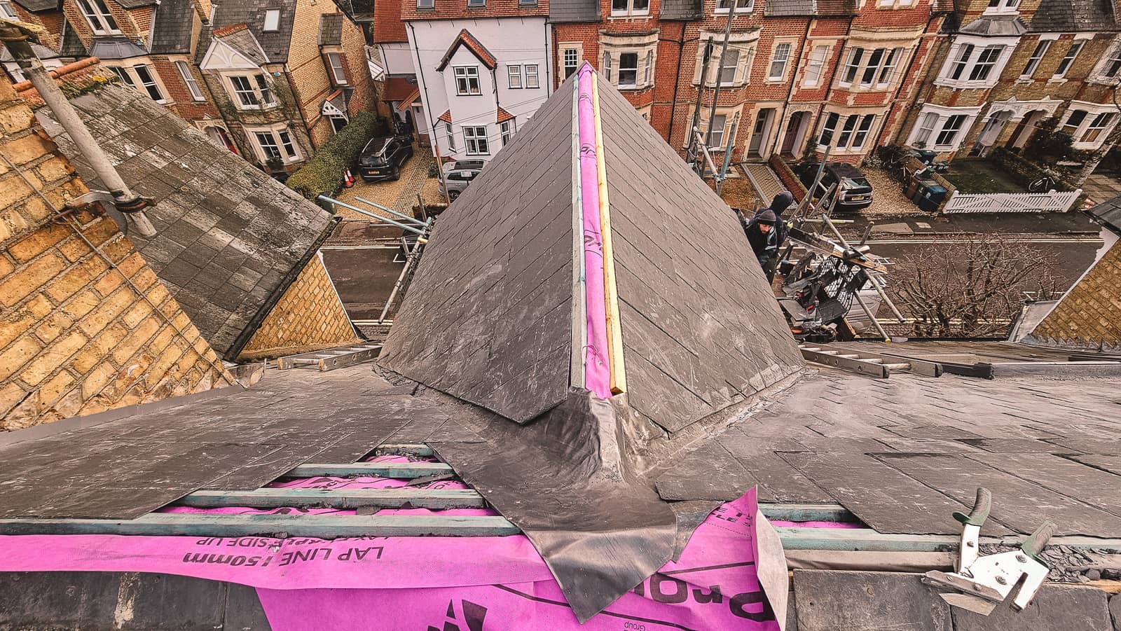New roof installation in progress with purple insulation and battens
