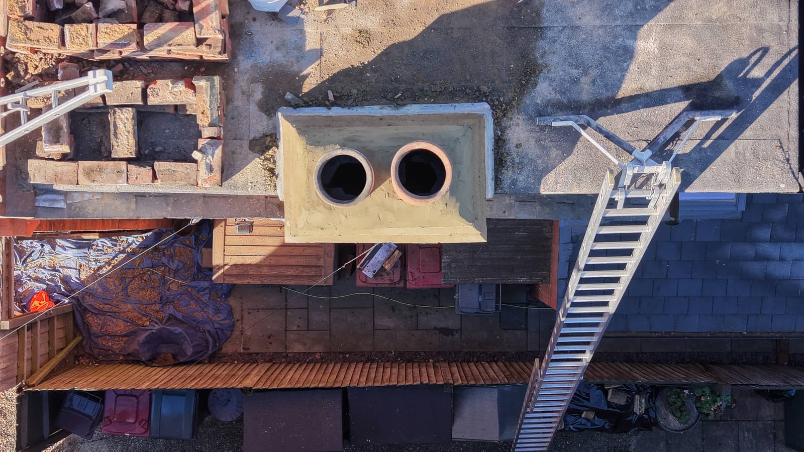 Aerial view of a residential roof and chimney stack after roofing work