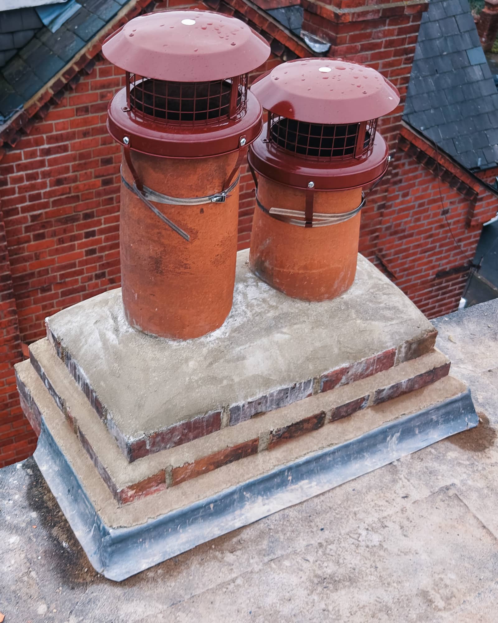 Aerial view of completed roofing work including chimney area