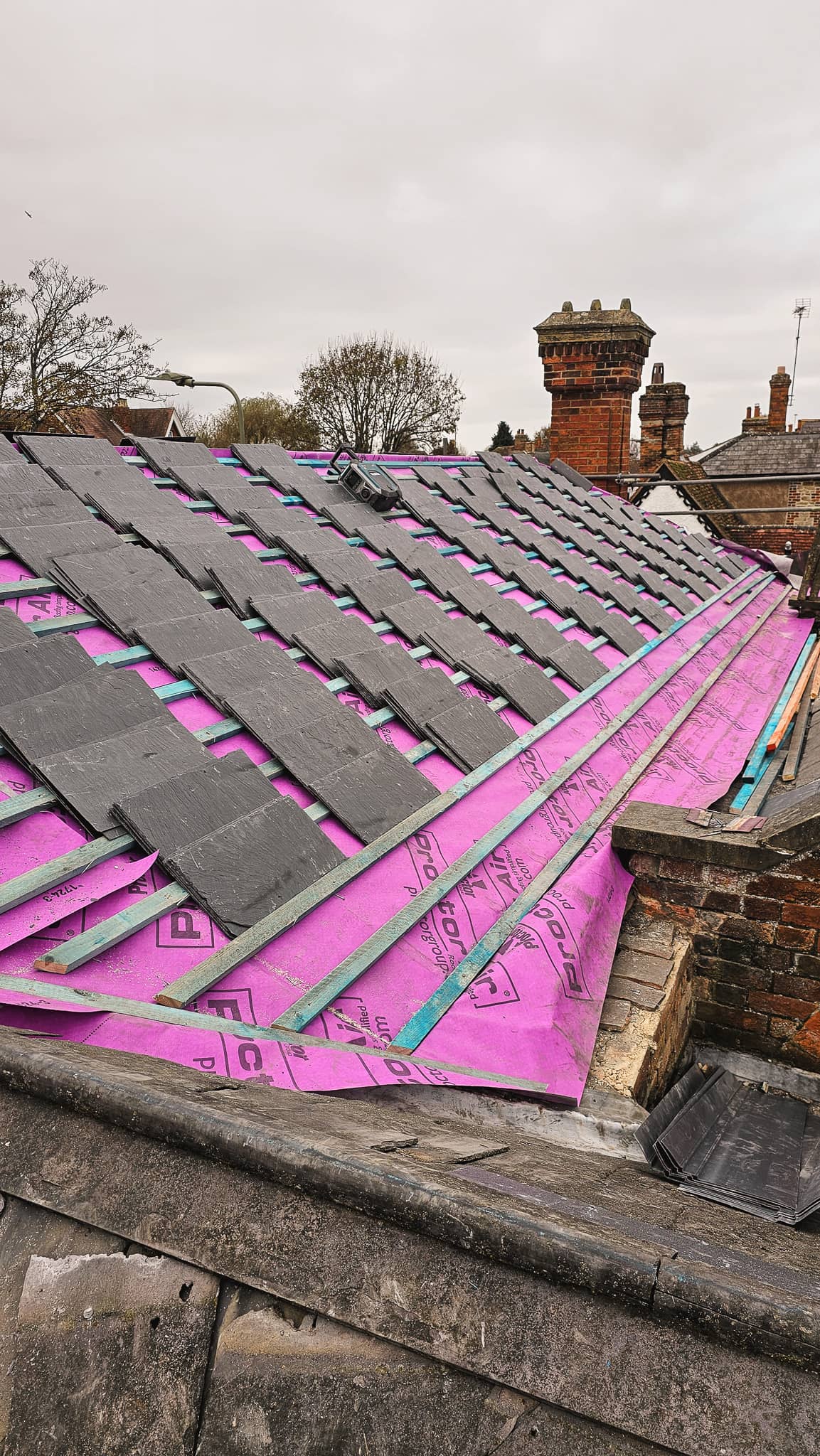 Completed new brown tiled roof with scaffolding after installation