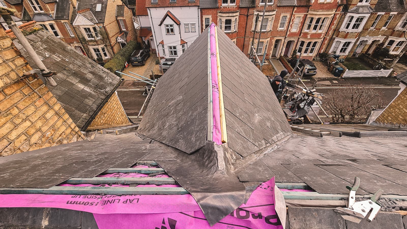 New roof installation in progress with purple insulation and tiles